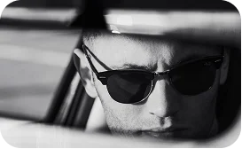 Close up reflection of a man wearing sunglasses in a car.