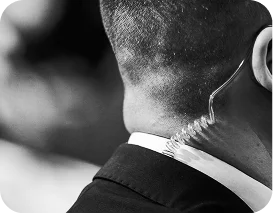 Back view of a security agent wearing a coiled earpiece for discreet communication, symbolizing professionalism.