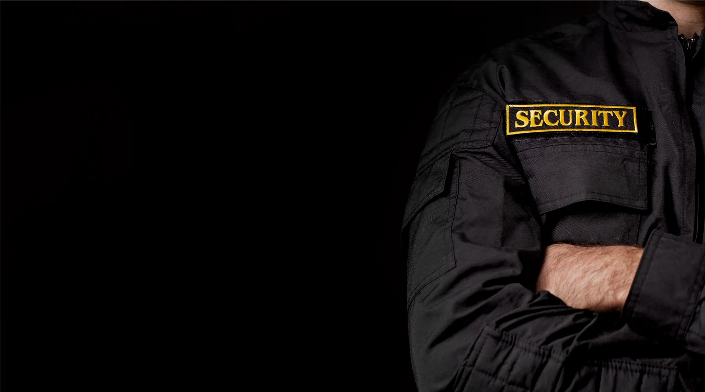 Close‑up of a security uniform patch with crossed arms